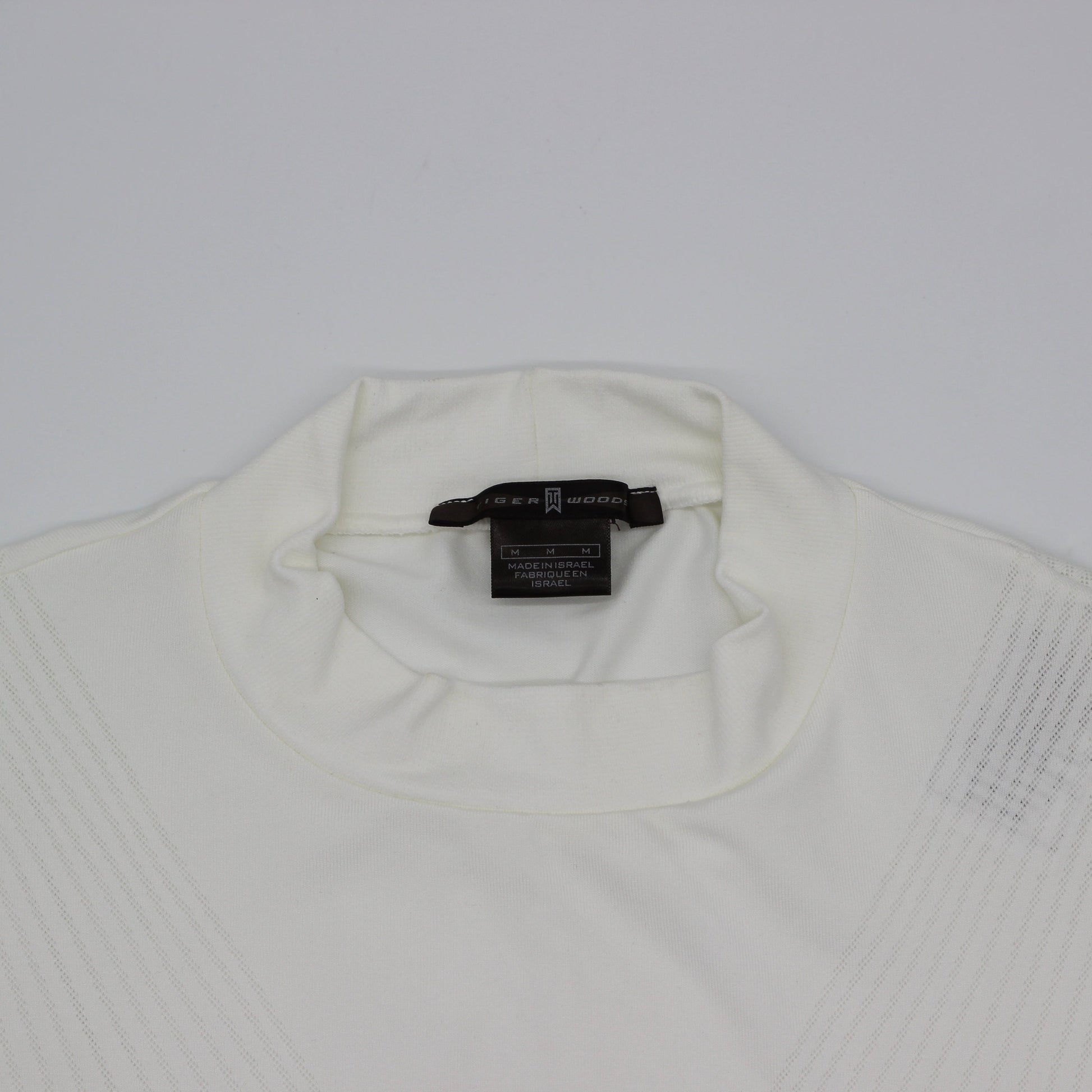 White Tiger Woods Mock Neck with a tag on a light gray background